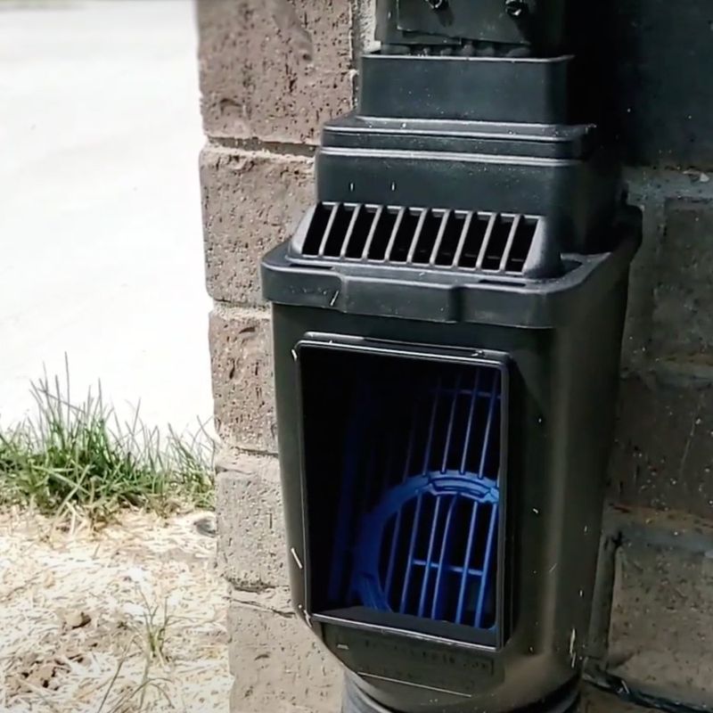 Downspout cleanout open showing leaf filter basket — Dakota Earthworks North Dakota