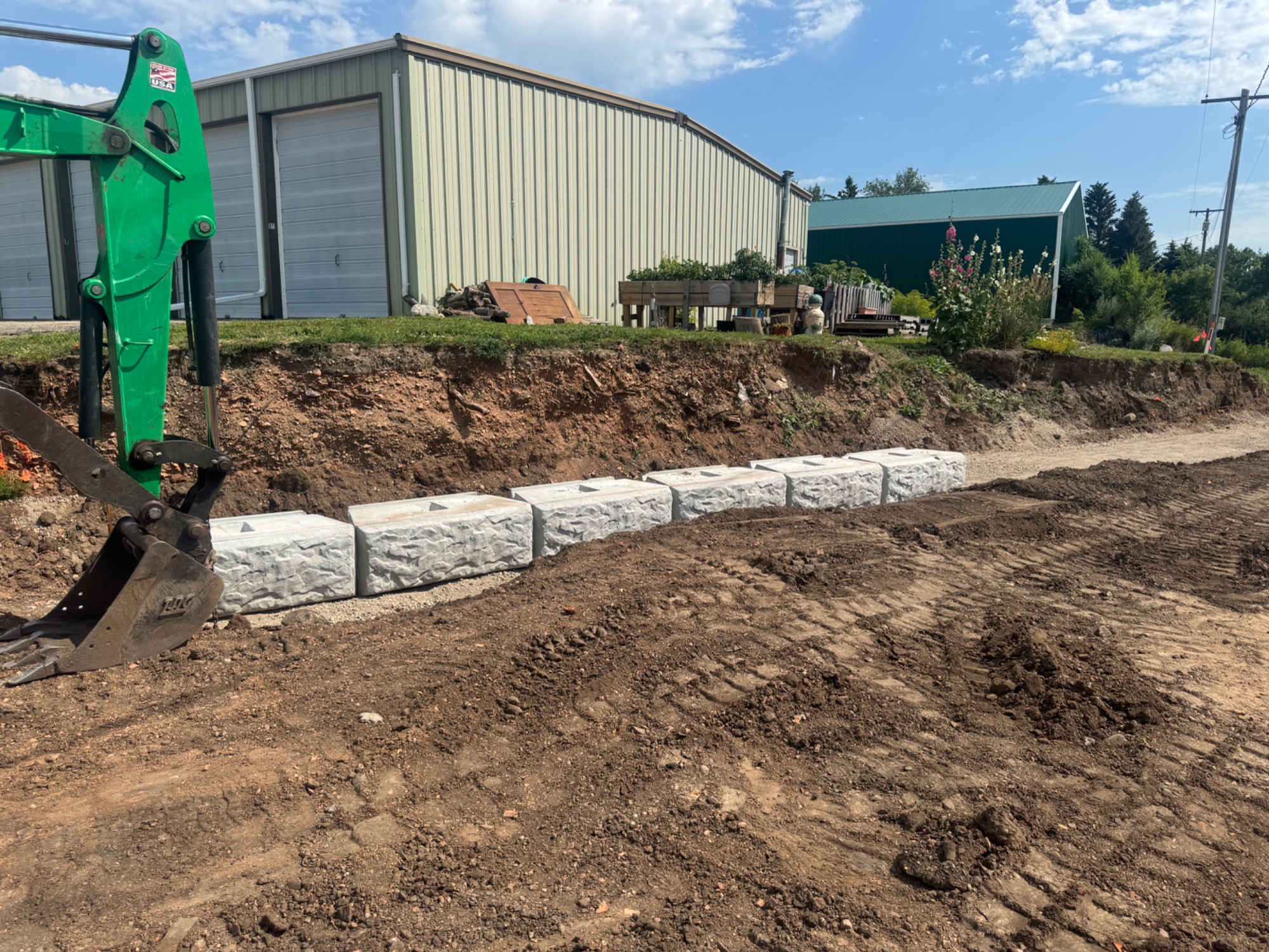 Concrete block retaining wall installation by Dakota Earthworks in Wilton, North Dakota