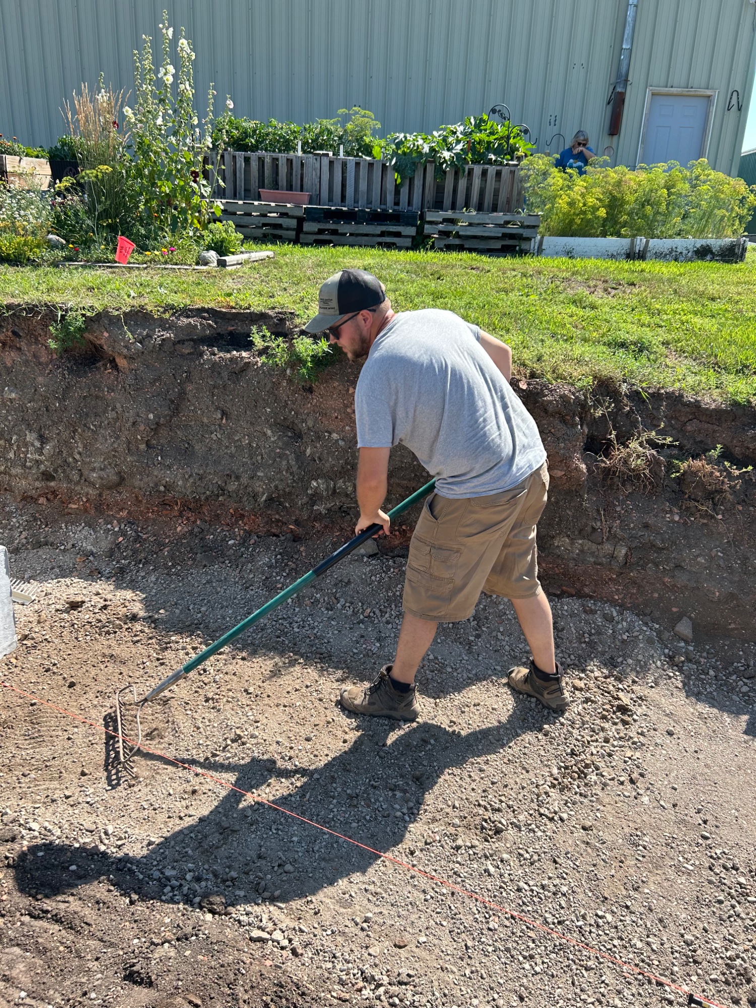 Hand grading and finishing work on retaining wall base in Wilton ND
